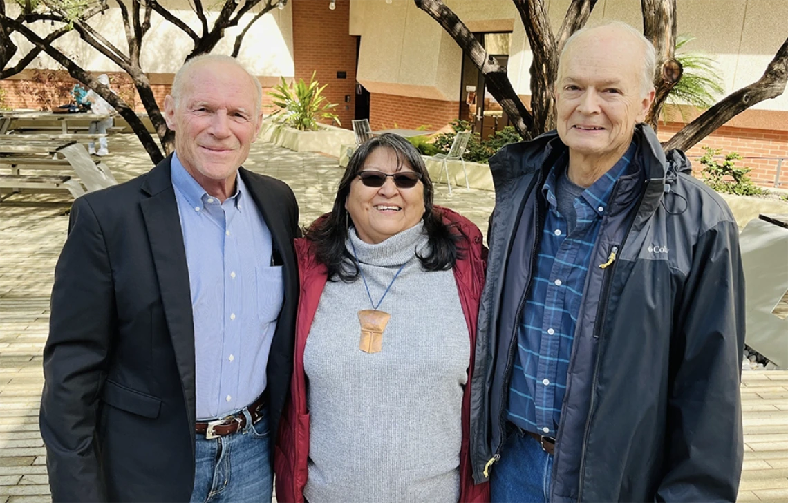 Joe Kalt, Joan Timeche, and Steve Cornell pose outside in the U of A law school courtyard